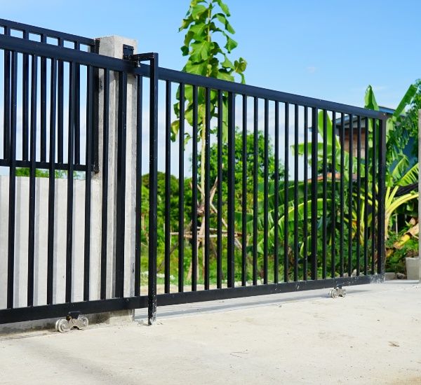 Sliding gate repair at a commercial property in bright daylight