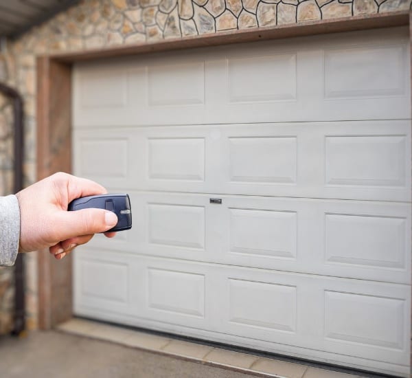 Remote control garage door opening at a residential home during the day