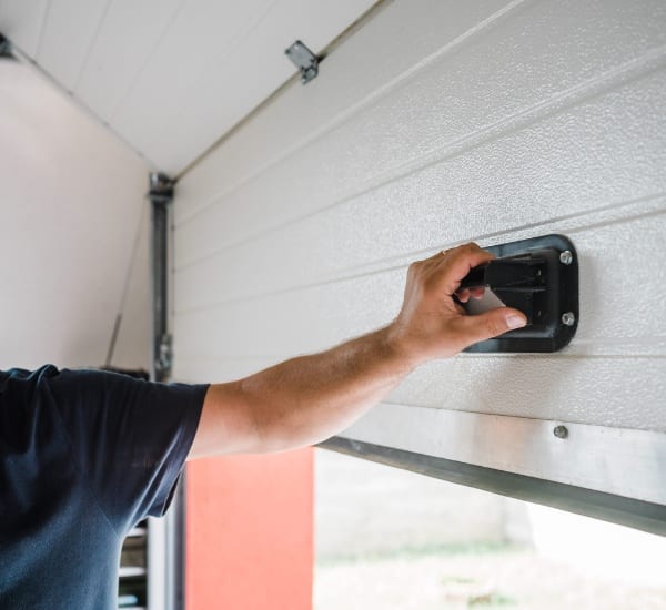 Hand operating garage door mechanism for smooth opening and closing in residential setting