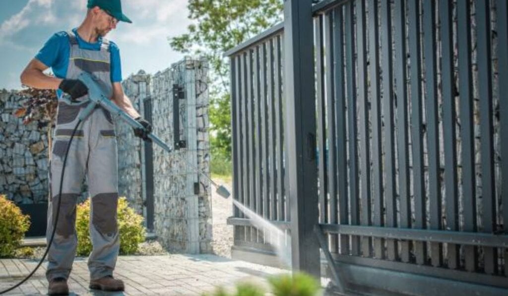 Technician adjusting a garage door spring with tools in hand.