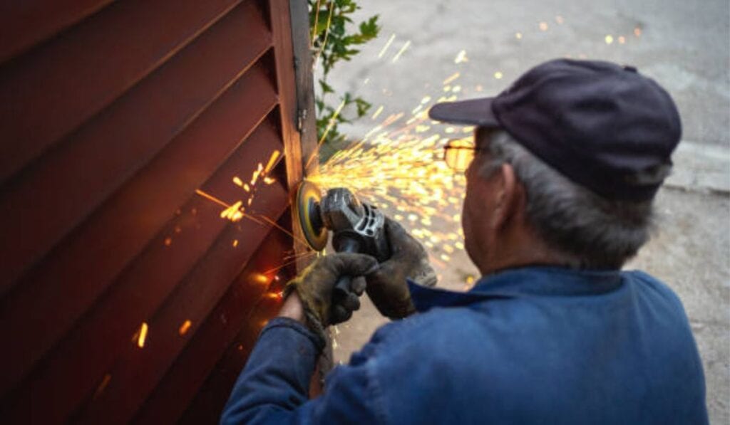 Electric gate control box with open wiring panel being tested for safety compliance
