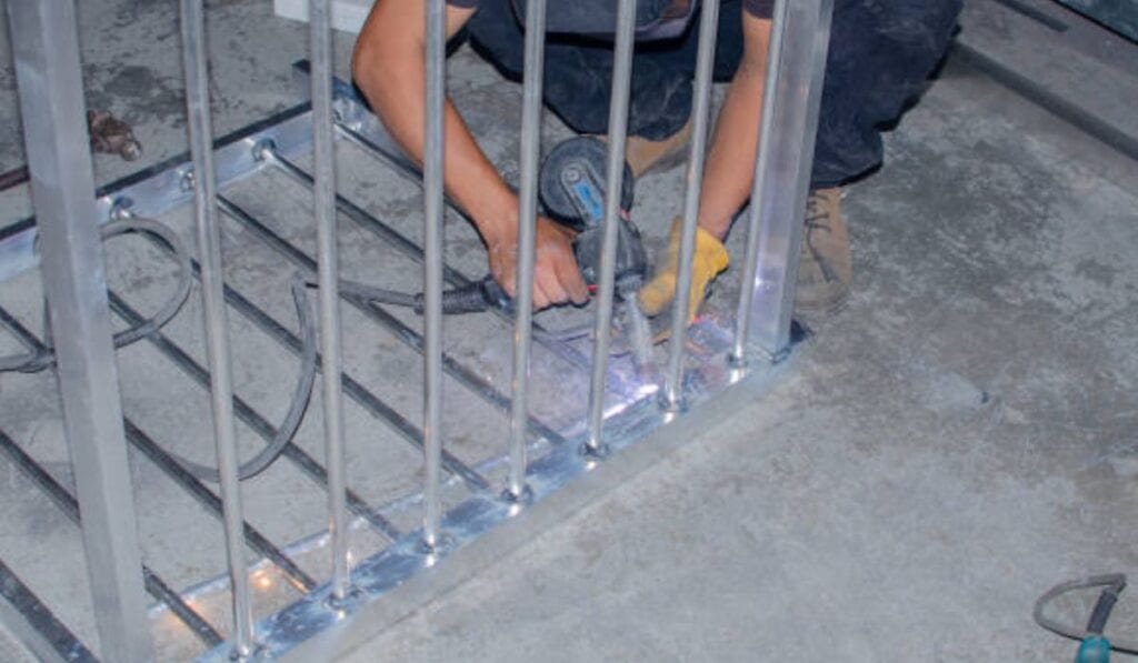Technician applying lubricant to a garage door track in a residential garage.