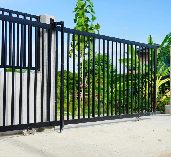 Sliding gate repair at a commercial property in bright daylight