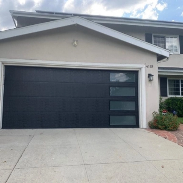 Emergency garage door repair service at residential home in the afternoon with technician working on the door