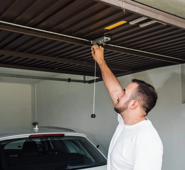 Man operating garage door opener in residential garage during daytime hours