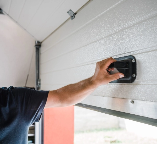 Hand operating garage door mechanism for smooth opening and closing in residential setting