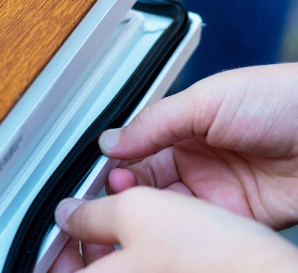 Hands adjusting a zipper on a fabric bag in an outdoor setting during daylight hours