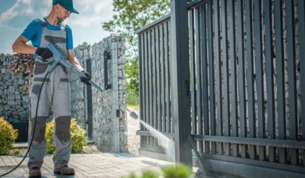 Technician adjusting a garage door spring with tools in hand.